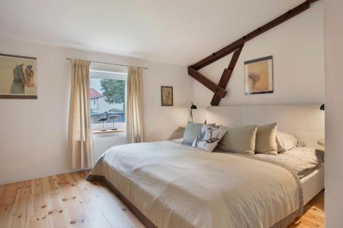 a bedroom with a large white bed with a window at Taubenkobel in Groß Wokern