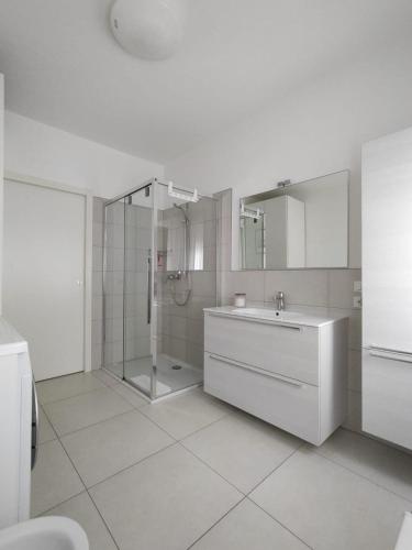a white bathroom with a sink and a shower at Apartment Mare Caorle int 1 in Caorle