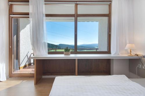 a bedroom with a bed and a large window at Fewo S22 in Regen