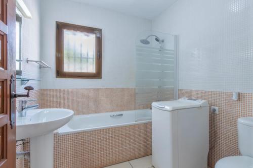 a bathroom with a sink and a tub and a toilet at Villa Margarita in Benissa