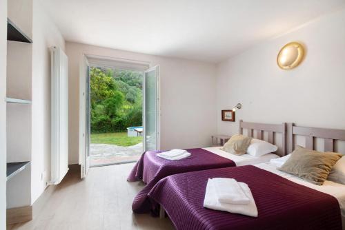 two beds in a room with a window at Villa Nespolo in Levanto
