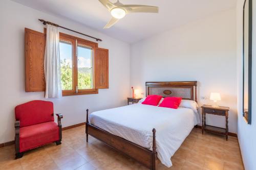 a bedroom with a bed and a red chair at Els Garroverets in Binissalem