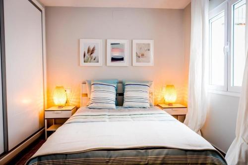 a bedroom with a large bed with two lamps at Apartment Dolmen de Viera in Antequera