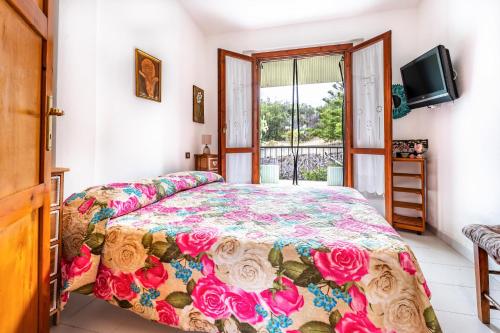 a bedroom with a bed with a floral bedspread at Villa Alice in Villasimius