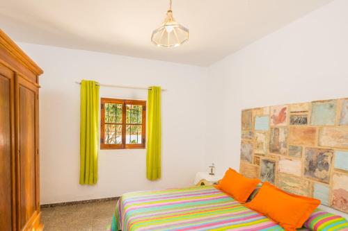 a bedroom with a bed and a window with green curtains at Casa de María in El Palmar