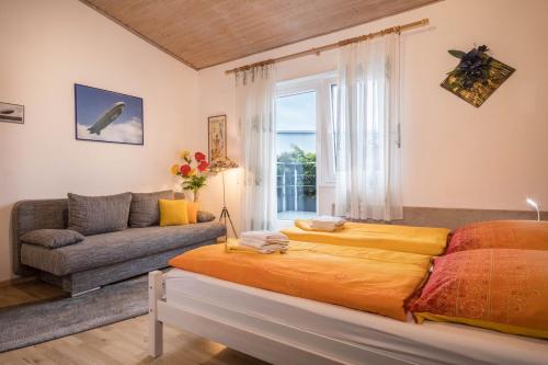 a bedroom with a large bed and a couch at B und E Röck in Meckenbeuren