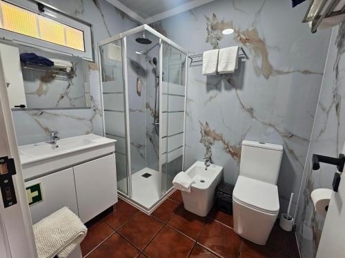 a bathroom with a toilet and a shower and a sink at Paradise House Furnas in Furnas