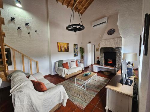 a living room with a couch and a fireplace at Paradise House Furnas in Furnas