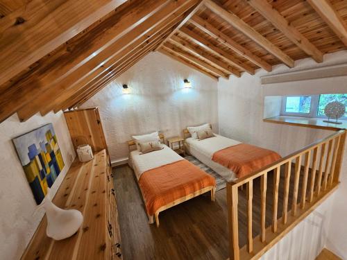 a attic room with two beds and a staircase at Paradise House Furnas in Furnas