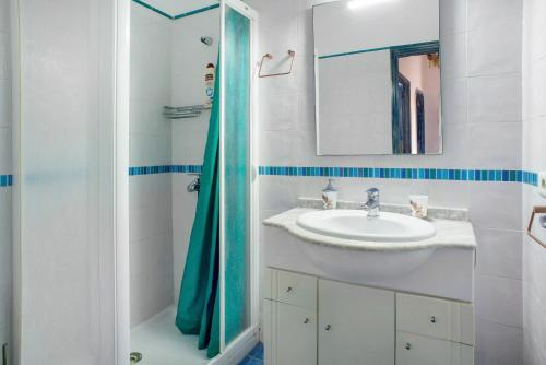 a white bathroom with a sink and a shower at Las Sales Duplex in Moya