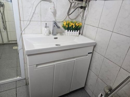 a white sink in a bathroom with flowers on it at Azis Hostel in Karatëbë