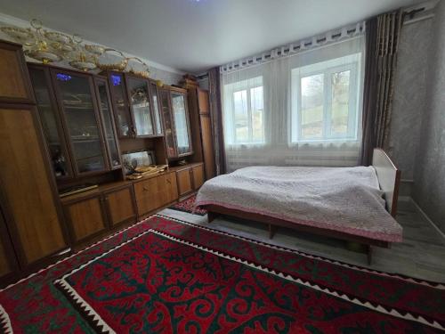 a bedroom with a bed and a window and a rug at Azis Hostel in Karatëbë