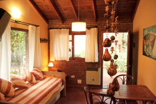 1 dormitorio con cama, mesa y ventana en Rincón de los Vientos en Mar de las Pampas