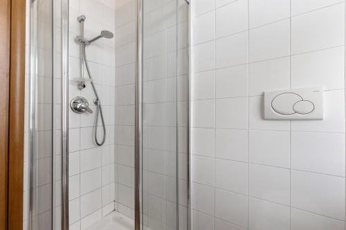 a shower in a bathroom with white tiles at B and B 7 Camini in Verona