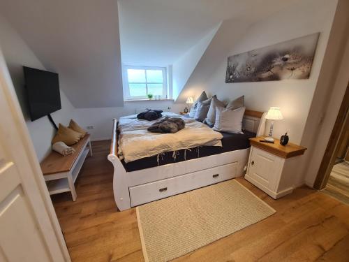 a bedroom with a bed with a cat laying on it at Rosenzauber Gipfelstürmer in Weißenstadt