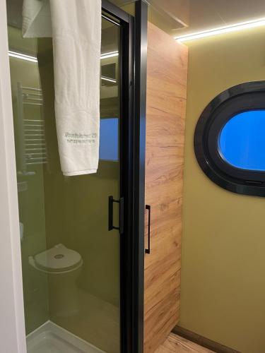 a bathroom with a toilet and a window at Hausboot mit Motorboot in Heiligenhafen