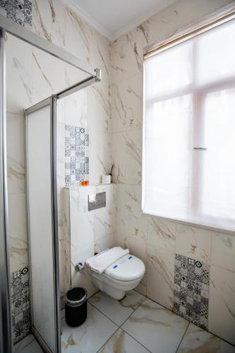 a bathroom with a toilet and a glass shower at 1826 Heritage Suites in Taksim