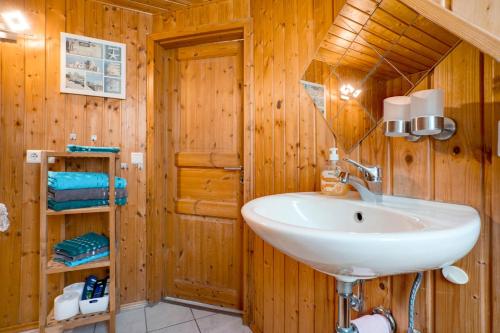 a bathroom with a sink and wooden walls at Ferienwohnung Kurzentrum in Bad Lausick