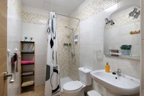 a bathroom with a toilet and a sink and a shower at Campo Amor Alto in Arrecife