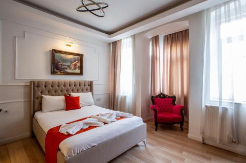 a bedroom with a bed and a red chair at 1826 Heritage Suites in Taksim