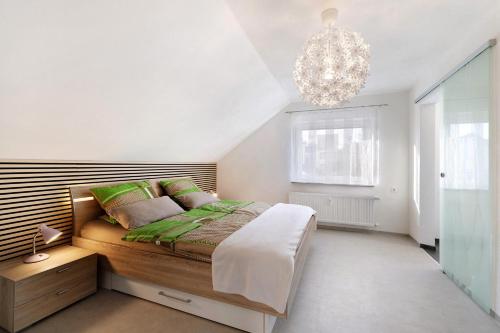 a bedroom with a large bed and a chandelier at Ferienwohnung Rosengarten in Mössingen