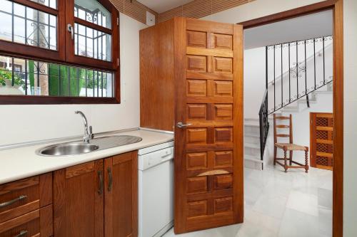 a kitchen with a sink and a wooden door at Dalias Nerja in Nerja