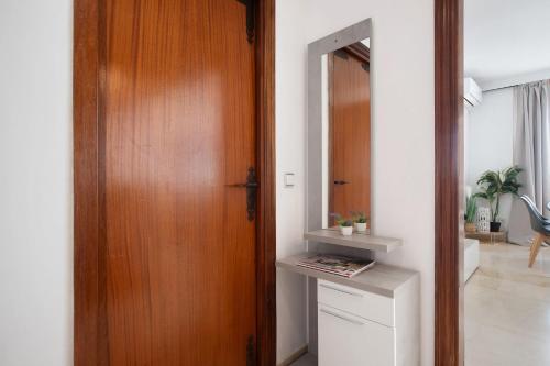 a hallway with a wooden door next to a room at Primera linea vistas panoramicas in Torremolinos