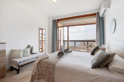 a bedroom with a large bed and a large window at Primera linea vistas panoramicas in Torremolinos
