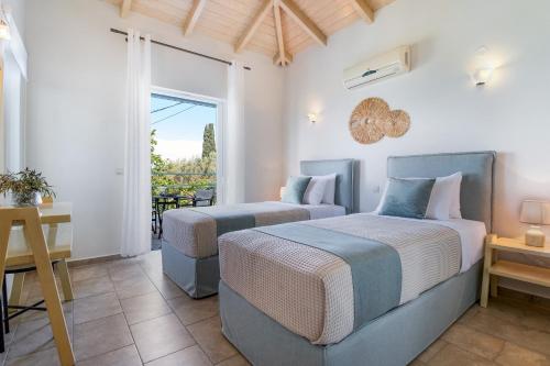 two beds in a room with a balcony at Villa Belvedere Verde in Lefkada