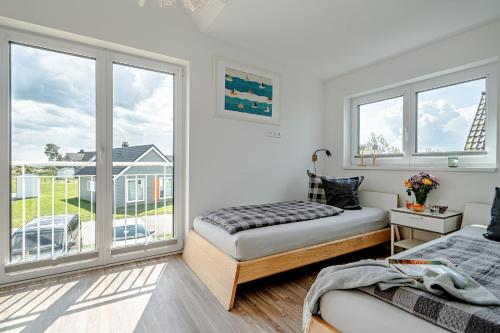 a bedroom with two beds and a large window at An der Ostsee by Seeblick Ferien in Kappeln