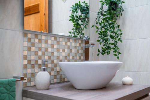 a bathroom with a white sink and some plants at Chelubirdi in Villasimius