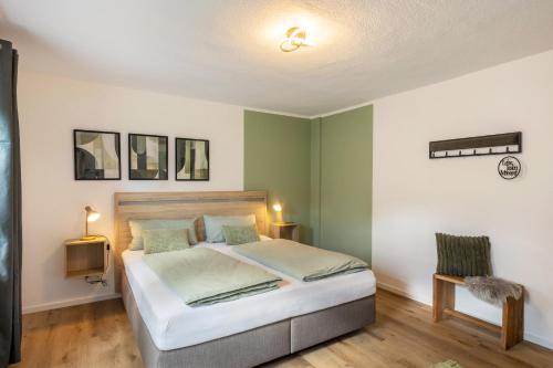 a bedroom with a large bed with green walls at Ferienwohnung-Bachlauf-Eslohe in Eslohe