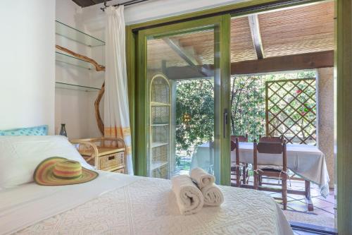 a bedroom with a bed and a sliding glass door at Villa Rosa in Porto Rotondo