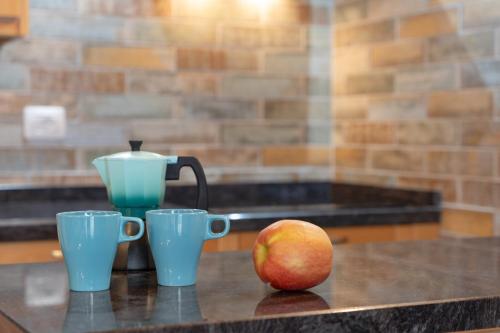 a table with two cups and an apple on it at Los Almendr2s in Frontera