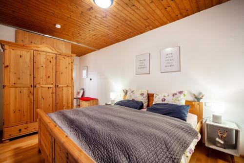 a bedroom with a bed and a wooden ceiling at Fewo in Urspring am Lechstausee in Steingädele