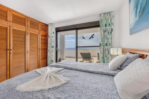 two beds in a bedroom with a view of the ocean at Beach House Christine in Costa Calma
