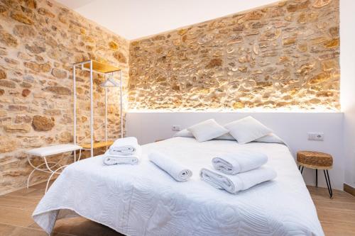 a bedroom with a white bed with towels on it at Casa del Campanar in Traiguera