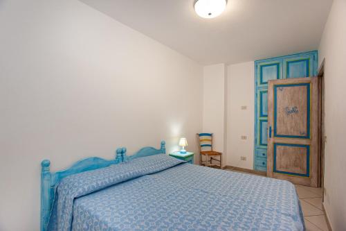 a bedroom with a blue bed and a blue door at Pavoncella in Orosei