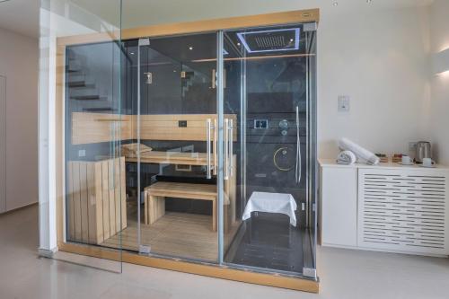 a glass enclosed room with a table and a chair at Villa Agave exclusive pool in Toscolano Maderno