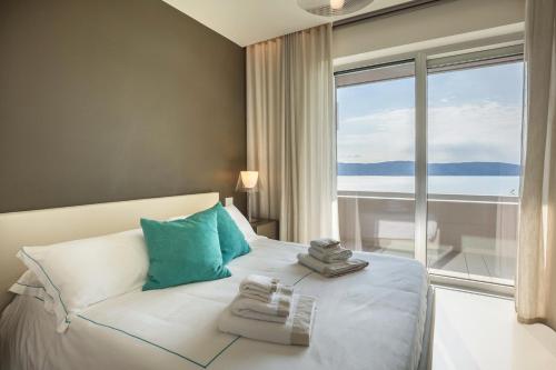 a bedroom with a bed with a view of the ocean at Villa Agave exclusive pool in Toscolano Maderno