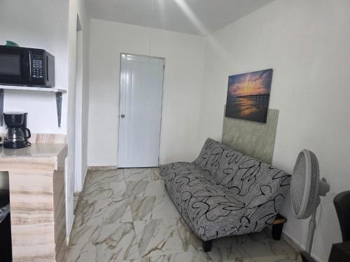 a living room with a couch and a microwave at Relax en el pueblo 2 in Fajardo