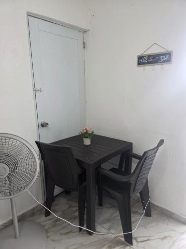 a black table and chairs in a room with a door at Relax en el pueblo 2 in Fajardo