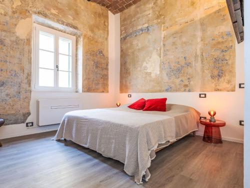 a bedroom with a bed with a red pillow on it at Apartment The Knight's Rest by Interhome in Bibbona