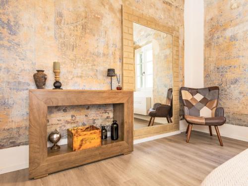 a room with a fireplace and a chair at Apartment The Knight's Rest by Interhome in Bibbona