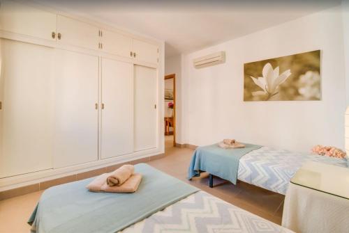 a bedroom with two beds and towels on the floor at Es Port penthouse in Santanyi