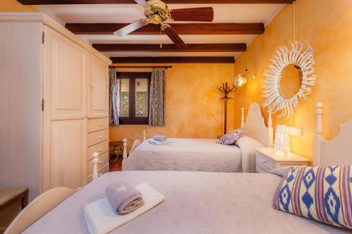 a bedroom with two beds and a ceiling fan at Ses Rodes in Felanitx
