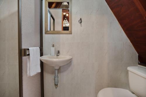 a bathroom with a sink and a toilet and a mirror at Chalets en Santa Elena en medio del Bosque in Medellín