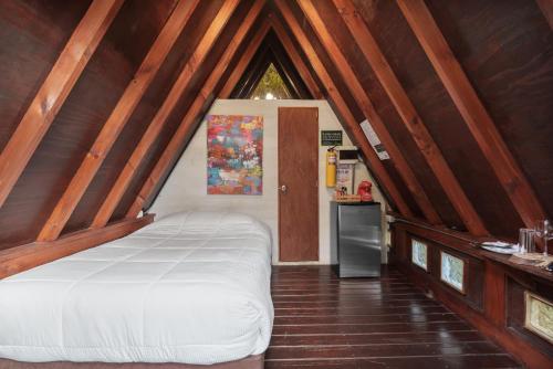 a bedroom with a white bed in a attic at Chalets en Santa Elena en medio del Bosque in Medellín