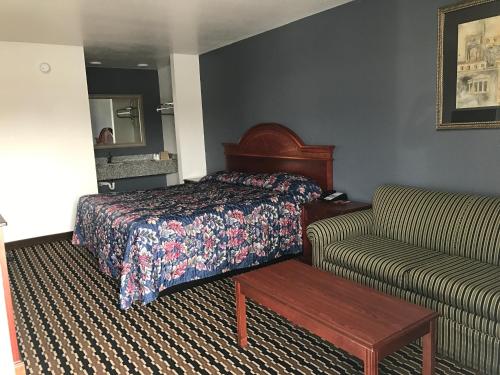 a hotel room with a bed and a couch at Sallisaw Inn in Sallisaw