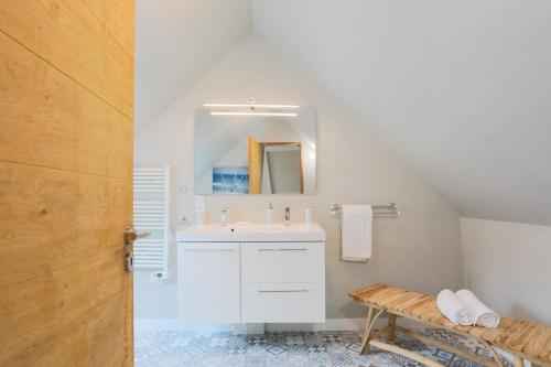 a white bathroom with a sink and a mirror at Le clos du Verdelet vue mer piscine in Planguenoual